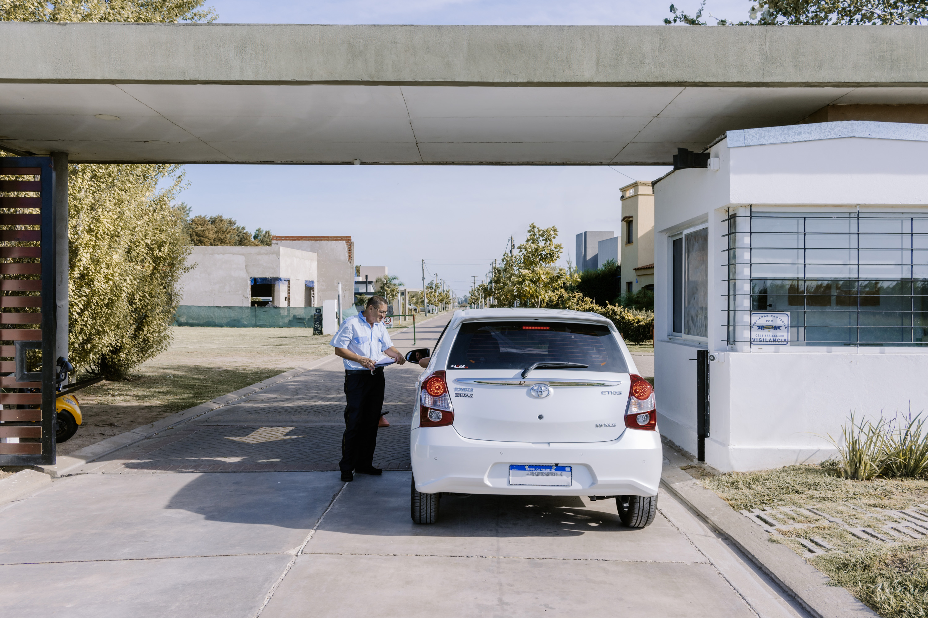 Vigilador registrando el ingreso de un vehículo en barrio cerrado